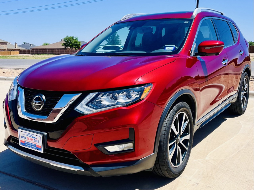 Red Nissan SUV at Hail Team One Auto Hail Repair Facility in Wolfforth Texas